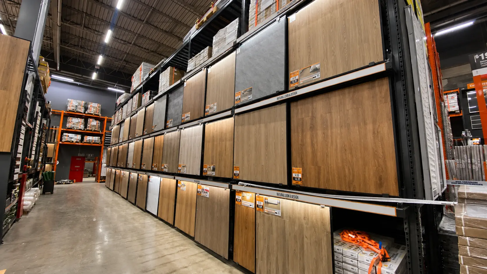 Corredor de Home Center com fileiras verticais de expositores de pisos vinílicos e laminados fabricados pela PDV Constru
